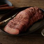 SADLER'S SMOKEHOUSE® TenderSplit beef brisket on a black serving platter.