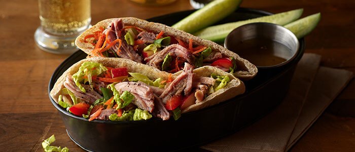 SADLER'S SMOKEHOUSE® pulled pork stuffed in pita pockets with salad.