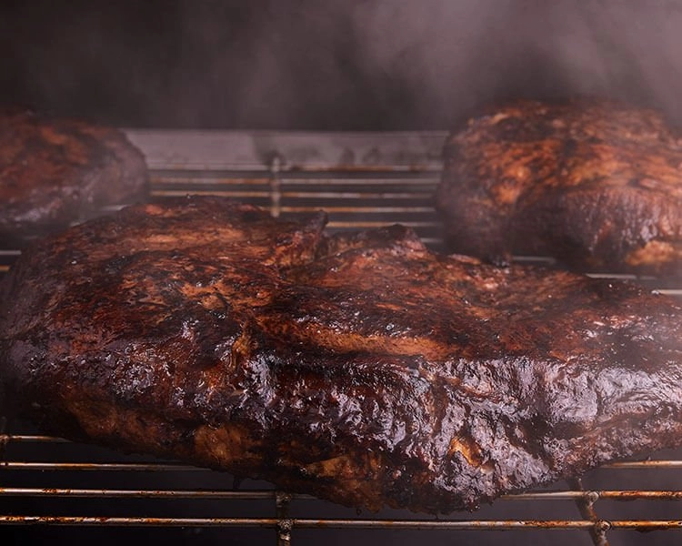 SADLER'S SMOKEHOUSE® brisket smoking on racks.